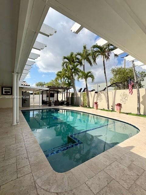 view of swimming pool with a fenced in pool, a fenced backyard, and a patio