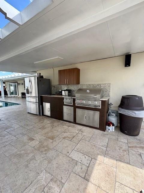 view of patio / terrace with a swimming pool, an outdoor kitchen, and area for grilling