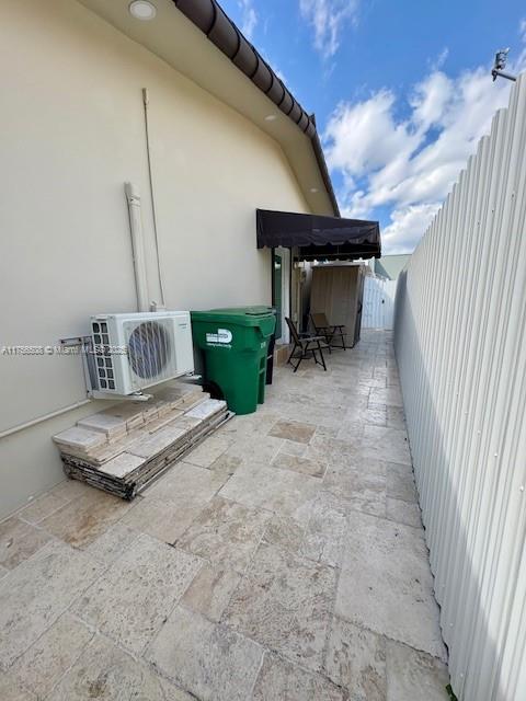 view of patio / terrace featuring ac unit and fence