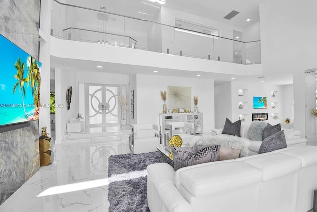 2578 NW 63rd Ln, Boca Raton, FL 33496 - living room with marble finish floor, a high ceiling, visible vents, and a glass covered fireplace