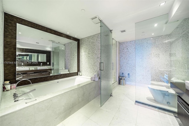 bathroom with a bidet, vanity, toilet, and tile walls