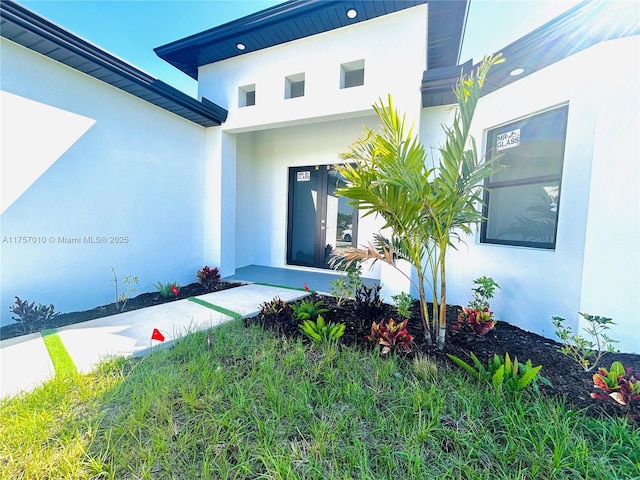 entrance to property featuring stucco siding