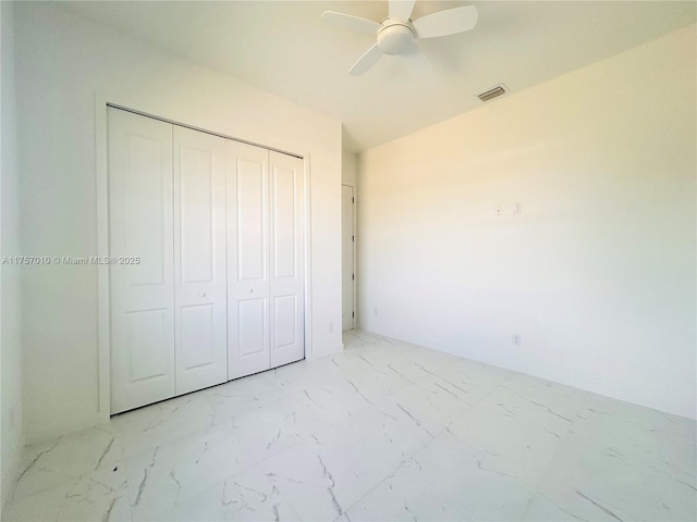 unfurnished bedroom featuring ceiling fan, marble finish floor, a closet, and visible vents