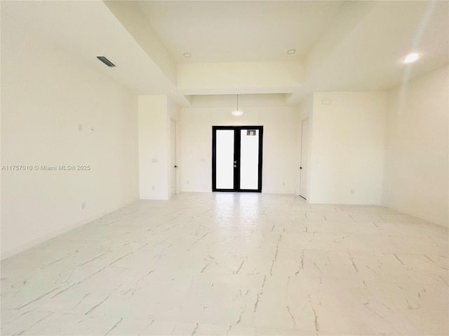 spare room with marble finish floor and french doors