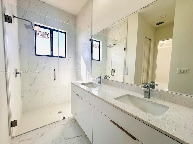 full bath featuring marble finish floor, a sink, and a marble finish shower