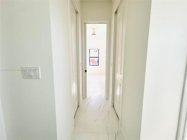 hall with marble finish floor and baseboards