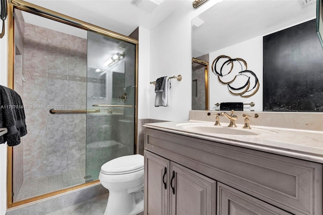 bathroom featuring toilet, visible vents, vanity, tile patterned floors, and a stall shower