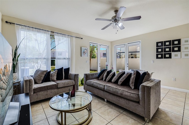 living area featuring a ceiling fan, baseboards, and light tile patterned floors