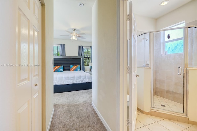 ensuite bathroom with a stall shower, connected bathroom, baseboards, and ceiling fan