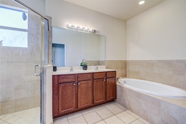 bathroom featuring double vanity, a stall shower, tile patterned floors, a sink, and a bath