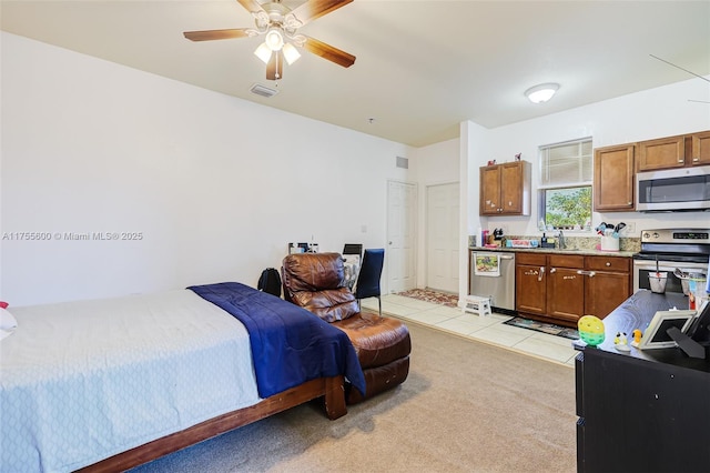 bedroom featuring light tile patterned floors, light colored carpet, visible vents, ceiling fan, and a sink