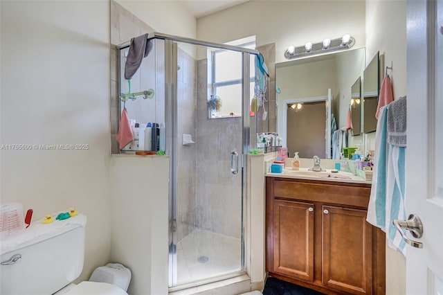 full bath with a stall shower, vanity, and toilet