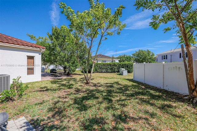 view of yard featuring central AC, a patio area, and fence