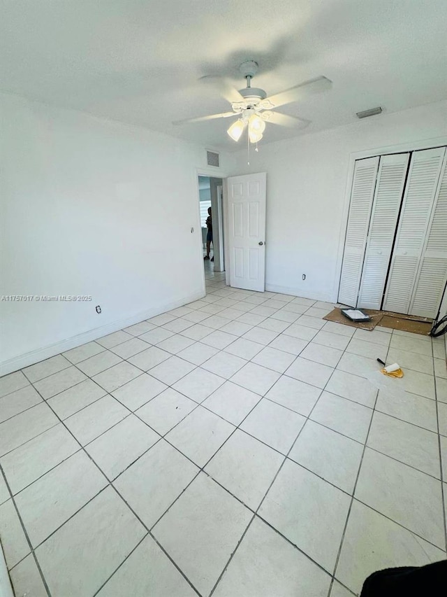 unfurnished bedroom with a ceiling fan, visible vents, baseboards, and a closet