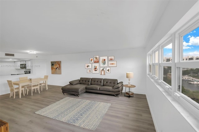 living area featuring visible vents, baseboards, and wood finished floors