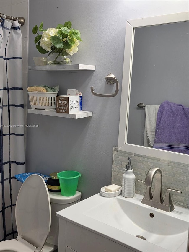 bathroom featuring curtained shower, vanity, toilet, and decorative backsplash