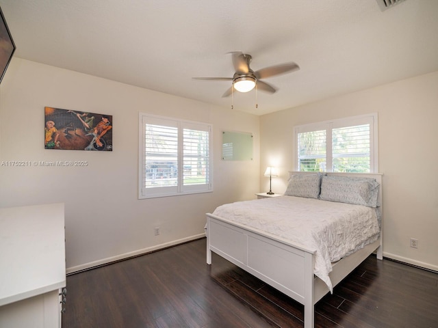 bedroom featuring dark wood-style floors, multiple windows, and baseboards