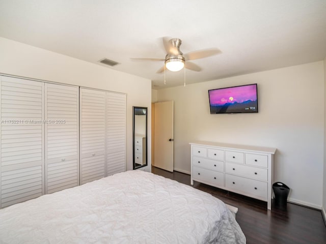 bedroom with visible vents, baseboards, a ceiling fan, dark wood-style floors, and a closet