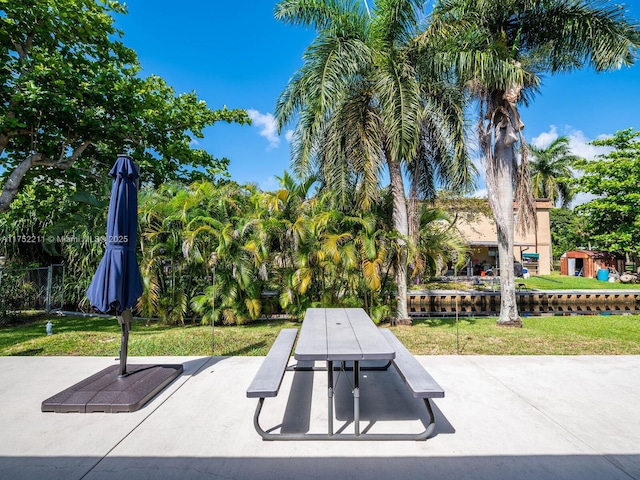 view of home's community with a patio area, fence, outdoor dining area, and a yard