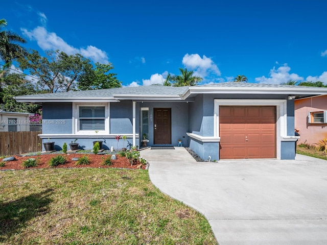 single story home with a garage, concrete driveway, stucco siding, fence, and a front yard