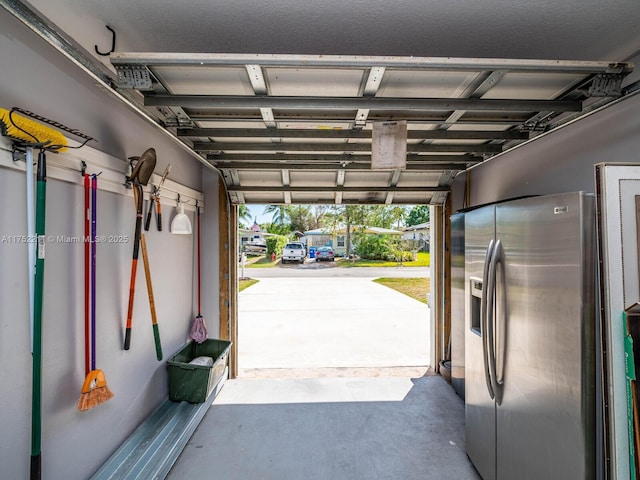 garage featuring stainless steel fridge with ice dispenser