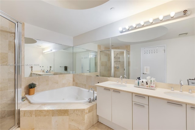 full bathroom with a sink, a shower stall, a tub with jets, and double vanity