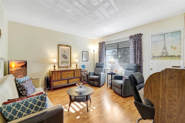 living room with a textured ceiling and light wood finished floors