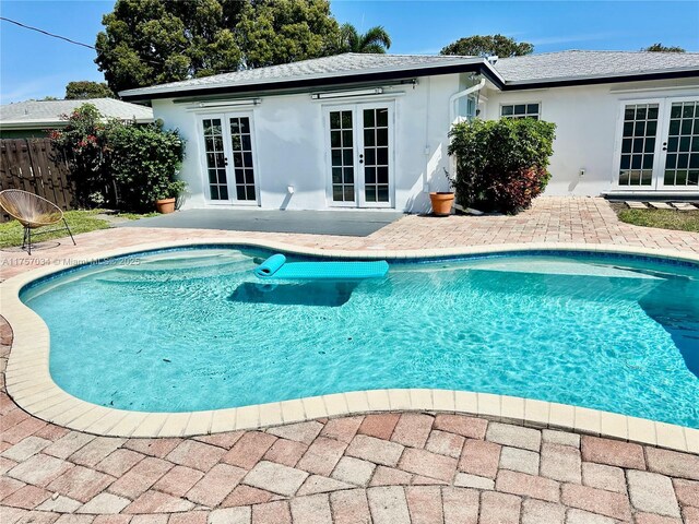 view of pool featuring a fenced in pool, fence, a patio, and french doors