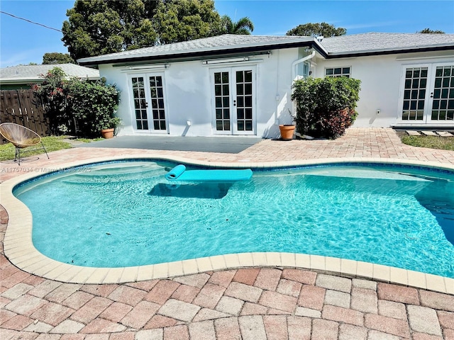 view of swimming pool with a fenced in pool, fence, a patio, and french doors