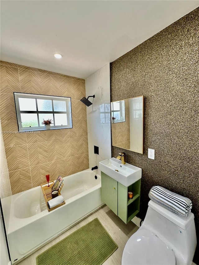 bathroom featuring vanity, tile walls, toilet, and shower / bathtub combination