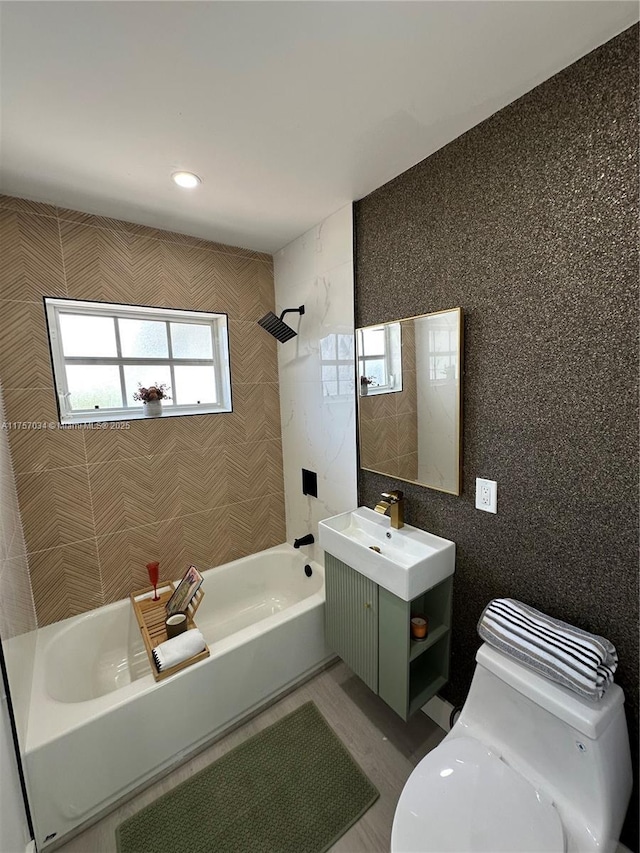 full bathroom featuring toilet, shower / tub combination, tile walls, and vanity