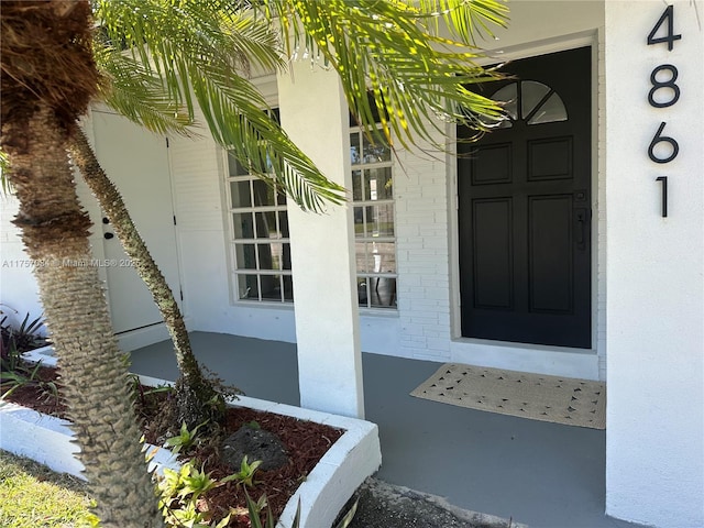 entrance to property featuring stucco siding