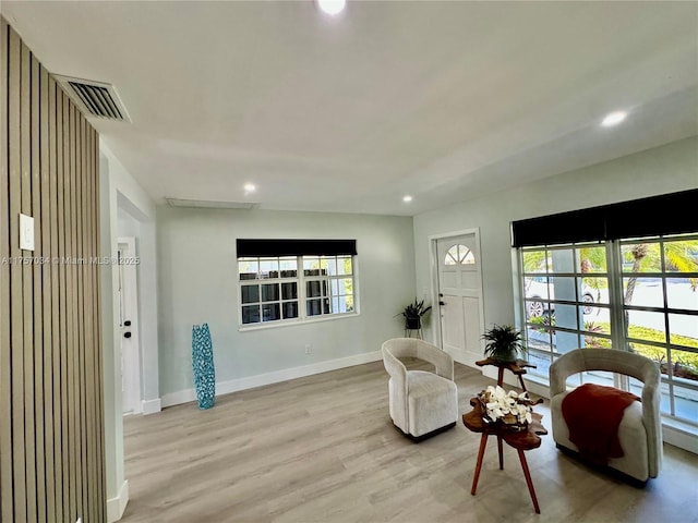 sitting room featuring a wealth of natural light, light wood-style flooring, visible vents, and baseboards