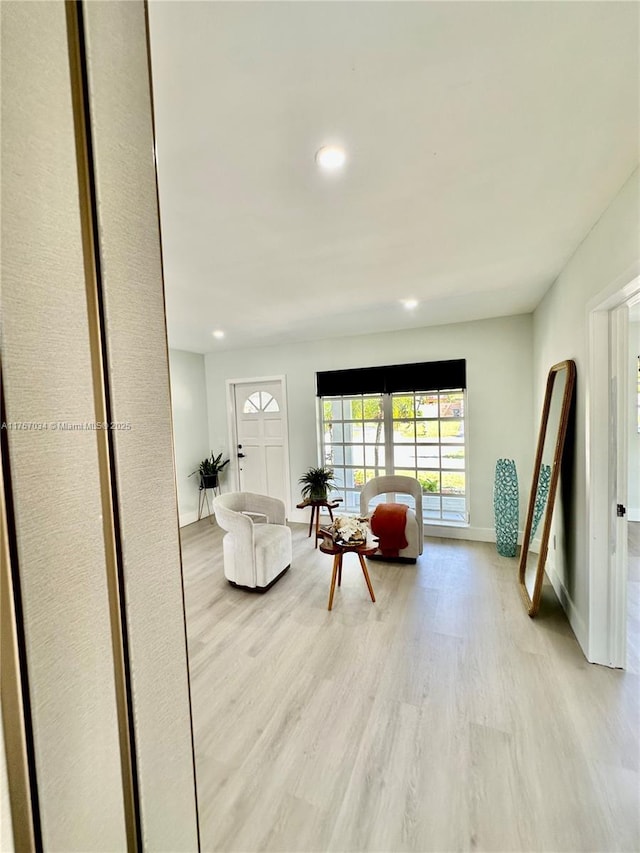 living area with light wood finished floors, baseboards, and recessed lighting