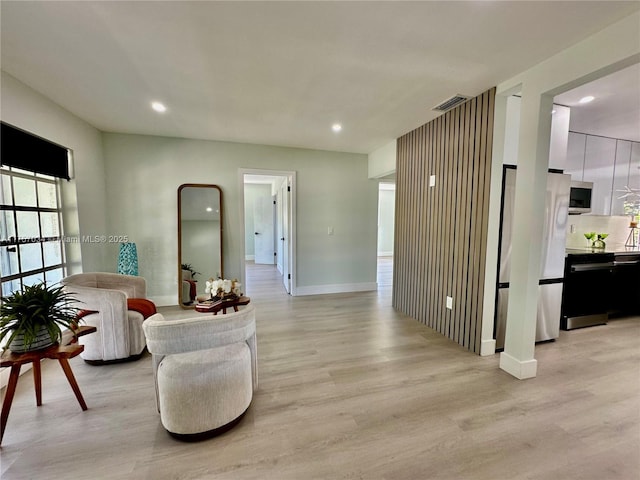 living area with visible vents, baseboards, light wood-style flooring, and recessed lighting