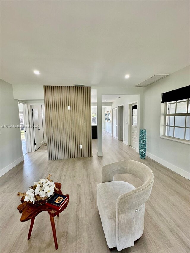 corridor with light wood-style floors, recessed lighting, visible vents, and baseboards