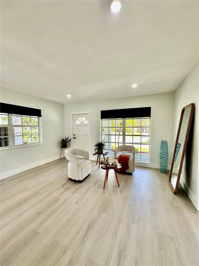 living area with light wood-type flooring, plenty of natural light, baseboards, and recessed lighting