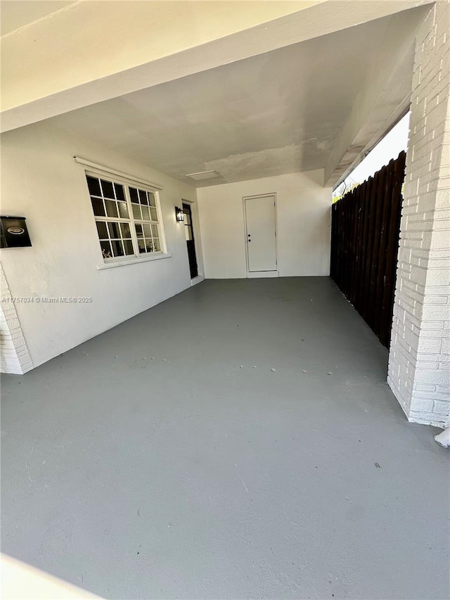 view of patio featuring an attached carport and fence