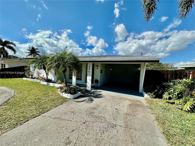 view of front of property featuring aphalt driveway, a front yard, and an attached carport