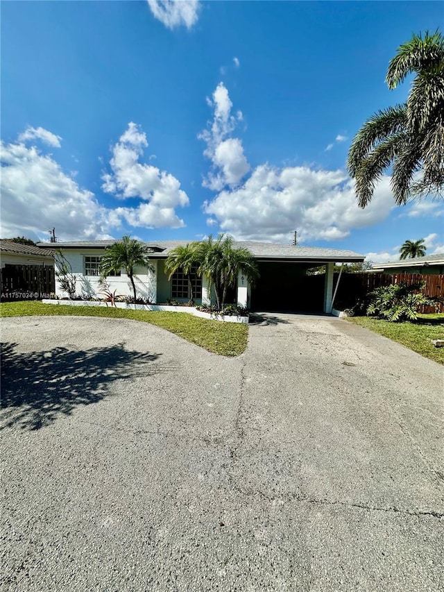 single story home featuring driveway and an attached carport