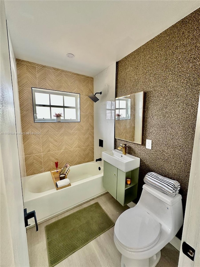 bathroom featuring tile walls, shower / bath combination, vanity, and toilet