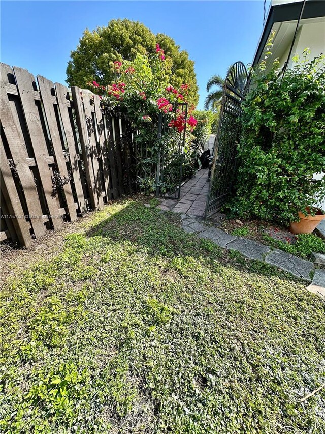 exterior space featuring an attached carport, brick siding, driveway, and fence