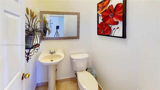 bathroom featuring toilet, tile patterned flooring, and baseboards