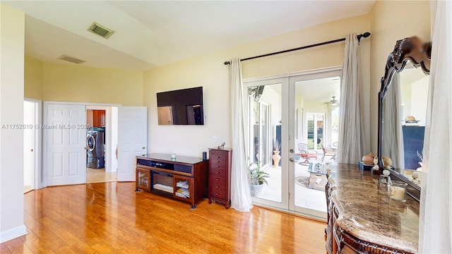 interior space with light wood-type flooring, french doors, and visible vents