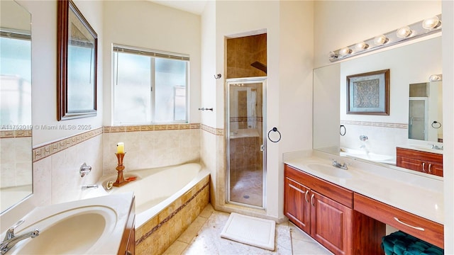 bathroom featuring a stall shower, two vanities, a garden tub, and a sink