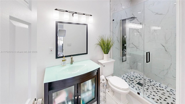 full bath featuring toilet, vanity, and a marble finish shower