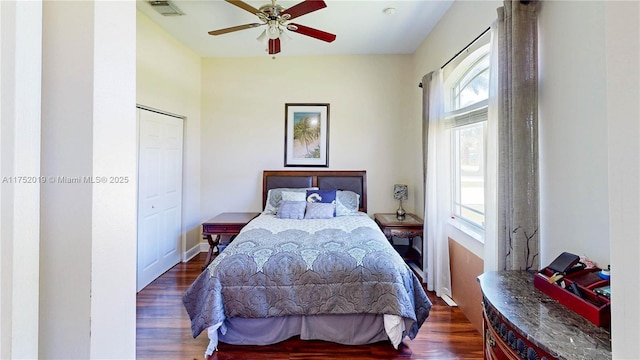 bedroom with a ceiling fan, baseboards, visible vents, and wood finished floors