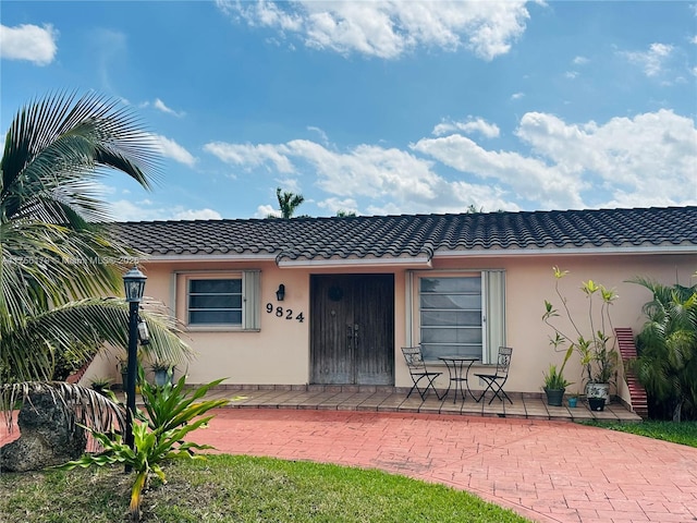 view of front of home with a tiled roof and stucco siding