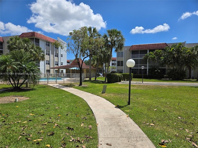 surrounding community with a gazebo, a lawn, and a swimming pool