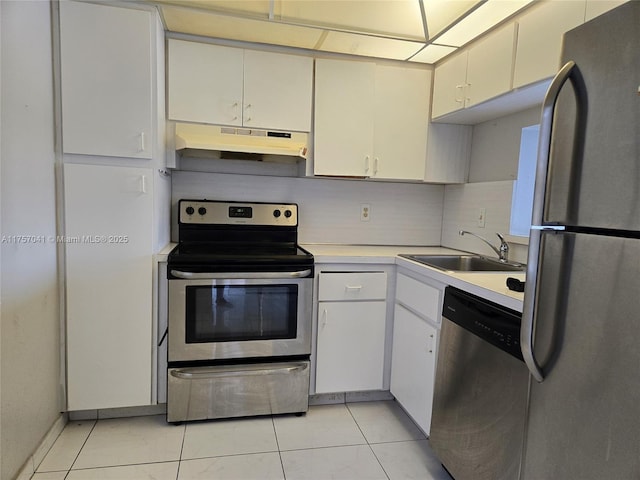 kitchen featuring light tile patterned floors, under cabinet range hood, stainless steel appliances, a sink, and light countertops